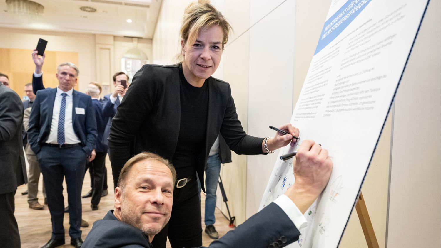 Klimaschutzministerin Mona Neubaur und Ulf C. Reichardt, Vorsitzender der Geschäftsführung von NRW.Energy4Climate unterzeichnen den Industriepakt.