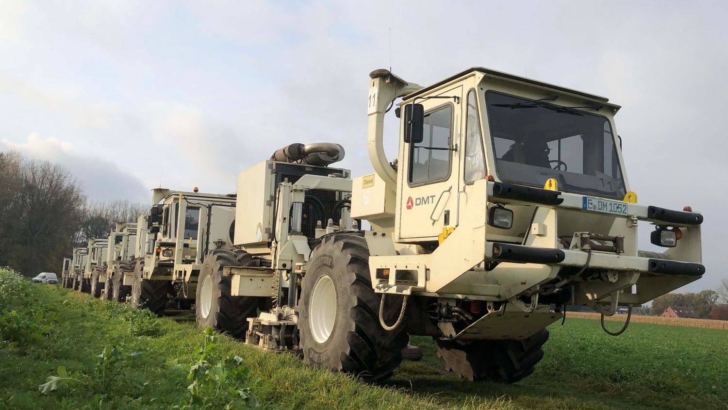 Mit ihren Vibrationselementen senden die Vibro-Trucks des GD NRW Schallwellen in den Untergrund. Die speziellen Vibro-Trucks des Geologischen Dienstes NRW stehen im Herbst 2022 auf einem Feldweg im Rheinland und sind bereit für den Beginn der Messkampagne.