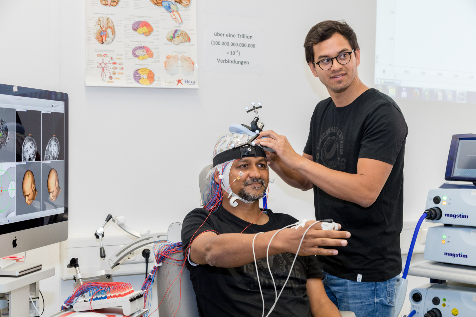 Spezielle Sensoren sind am Kopf eines Besuchers des Tags der Neugier 2019 angebracht. Sie werden für die Gehirnforschung genutzt. 