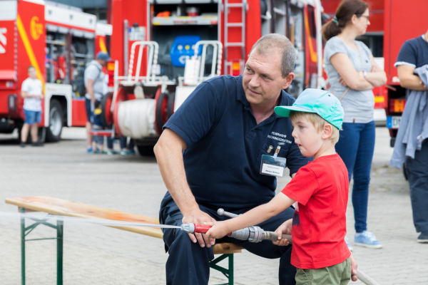 Bei der Werksfeuerwehr des Forschungszentrums Jülich darf sich ein Junge am Wasserstrahlrohr ausprobieren. 