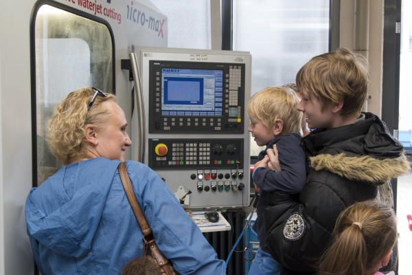 Eine Besucherin wagt mit ihren Kindern einen neugierigen Blick in das Schaufenster einer Versuchsanordnung. 